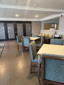 a waiting room with tables and chairs in a hospital at Hampton Inn South Heritage Park in Lincoln