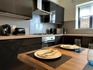 a kitchen with a wooden table with plates and napkins at Seaview Penthouse in Seaham