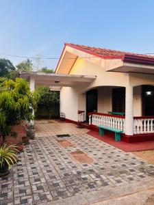 a house with a bench in front of it at Ceylon Glory Hostel in Negombo