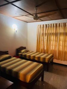 two beds in a room with a curtain at Ceylon Glory Hostel in Negombo