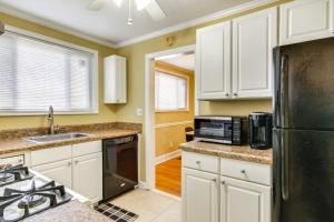 eine Küche mit weißen Schränken und einem schwarzen Kühlschrank in der Unterkunft Augusta Home with Fenced Yard - 4 Mi to Downtown! in Augusta