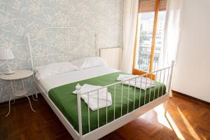 - une chambre avec un lit blanc et une couverture verte dans l'établissement A.I.R. Sorrento Apartment 2, à Sorrente