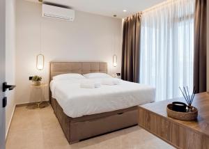 - une chambre avec un grand lit et une grande fenêtre dans l'établissement Ioannina Secret Luxury Villas, à Ioannina