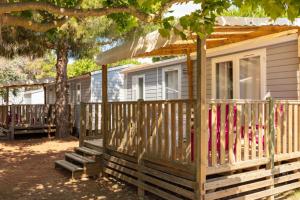 une maison dotée d'une clôture en bois avec des chauves-souris dans l'établissement Camping Saint-Nazaire, à Saint-Nazaire