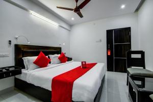 a bedroom with a large bed with a red blanket at Super Collection O Ramachandra Residency in Kurmannapalem