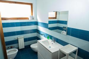 ein blau-weißes Bad mit einem Waschbecken und einem WC in der Unterkunft A.I.R. Sorrento Apartment 2 in Sorrent