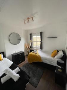 a bedroom with two beds and a mirror at The Luxury Hogwarts retreat! Perfect for Harry Potter World Watford & Central London With Parking in Watford