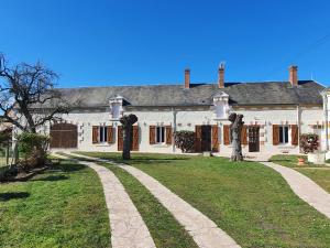 uma grande casa branca com duas estátuas em frente em Les camélias em Selles-sur-Cher