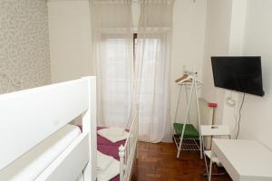 Cette chambre blanche comprend un lit et une télévision. dans l'établissement A.I.R. Sorrento Apartment 2, à Sorrente
