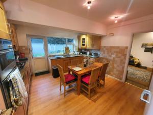 a kitchen with a table and chairs in a room at Detached 4-Bed House in Leeds in Leeds