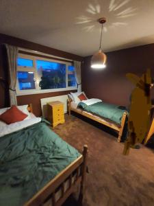 a bedroom with two beds and a window at Detached 4-Bed House in Leeds in Leeds