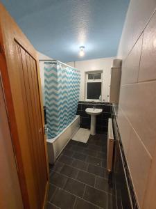 a bathroom with a tub and a sink and a toilet at Detached 4-Bed House in Leeds in Leeds