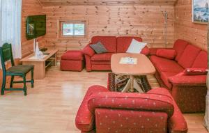 - un salon avec des canapés rouges et une télévision dans l'établissement Stunning Apartment In Sjernary With House Sea View, à Sjernarøy