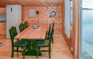 - une salle à manger avec une table et des chaises en bois dans l'établissement Stunning Apartment In Sjernary With House Sea View, à Sjernarøy
