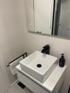 a bathroom with a white sink and a mirror at Seaside Apartment Sleeps 6 with Balcony in Vilagarcia de Arousa +17 photos