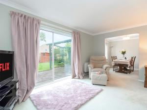 a living room with a tv and a large window at Bluebell House in Bishop Auckland