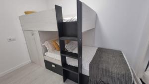 a black bunk bed in a white room at Seaside Apartment Sleeps 6 with Balcony in Vilagarcia de Arousa