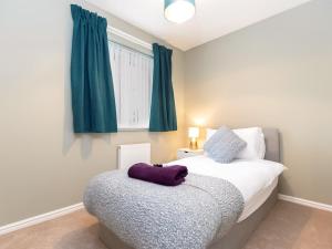 a bedroom with a bed and a window with blue curtains at Bluebell House in Bishop Auckland