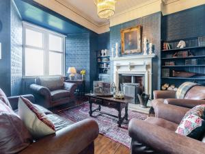 a living room with leather furniture and a fireplace at Heatherdene in Goathland