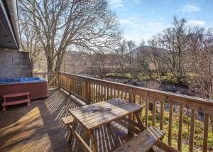 a wooden deck with a picnic table on it at Wildside Highland Lodges in Whitebridge