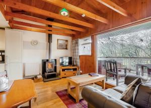 a living room with a couch and a stove at Wildside Highland Lodges in Whitebridge