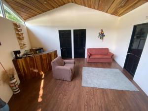 a living room with two chairs and a rug at Grand Park Manuel Antonio - Adults Only in Manuel Antonio