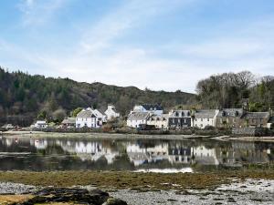 a group of houses next to a body of water at Hirta in Plockton