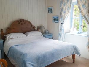 a bedroom with a large bed with a large window at Sunnyhill in Brigsteer