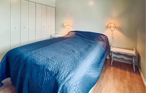 a bedroom with a bed with a blue blanket on it at Stunning Home In Svingvoll With House A Mountain View in Svingvoll