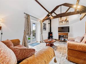 a living room with two couches and a tv at The Cottage in South Barrow