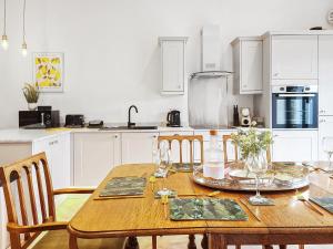 a kitchen with a wooden table with chairs and a dining room at William House - Uk39787 in Burton in Lonsdale