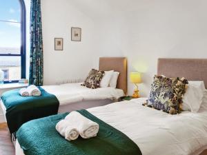 two beds in a room with towels on them at William House - Uk39787 in Burton in Lonsdale