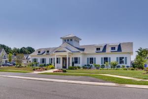 a large white house with a driveway at Luxe Rehoboth Beach House with Community Pool and Gym! in Rehoboth Beach
