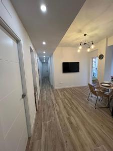 Una sala de estar con una mesa y un televisor. en Annamaria B&B Alicante Centro, en Alicante
