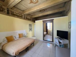 1 dormitorio con 1 cama y TV de pantalla plana en Villa Archi, en Faenza