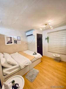 een kleine slaapkamer met een bed en een houten vloer bij Korean Themed Condo Staycation in Marilao, Bulacan in Marilao