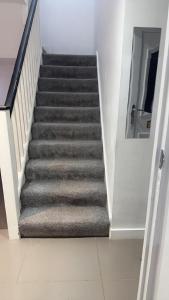 a staircase in a house with grey carpet at Cosy and Unique Bedroom In Gateshead in Sheriff Hill