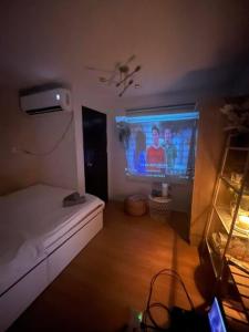 Zimmer mit einem TV und einem Bett in einem Zimmer in der Unterkunft Korean Themed Condo Staycation in Marilao, Bulacan in Marilao