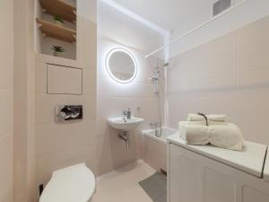a white bathroom with a sink and a toilet at Bonifraterska Papaya Apartment in Warsaw