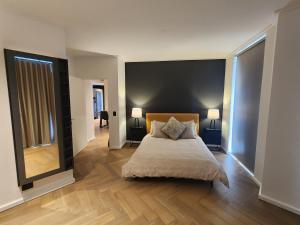 a bedroom with a large bed and two lamps at NINE PALMS in Cape Town