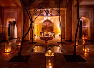 a room with a fountain in the middle of a building with lights at Dar Les Cigognes in Marrakesh