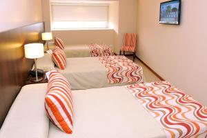 two beds in a hotel room with two bedsskirts at Hotel Intersur San Telmo in Buenos Aires