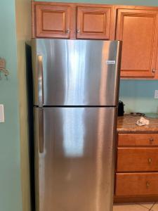 a stainless steel refrigerator in a kitchen with wooden cabinets at Unit #302-2br2ba-3rd Floor Ocean Views in Wildwood