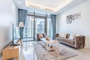 een woonkamer met een bank en een tafel bij Stunning 2br With Burj Views Infinity Pool in Dubai