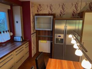 Il comprend une cuisine équipée d'un réfrigérateur en acier inoxydable et d'une table. dans l'établissement Ferienhaus ideal für Monteure, à Stemwede