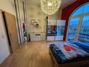 Un dormitorio con una cama grande y una lámpara de araña. en Ferienhaus ideal für Monteure, en Stemwede