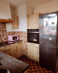 a kitchen with a stainless steel refrigerator and a microwave at Appartement chez Eline in Les Angles Gard