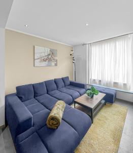 sala de estar con sofá azul y mesa en Escapade Authentique, en Aubange