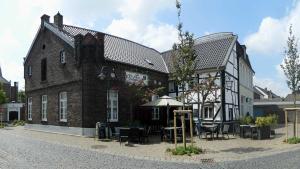 a building with tables and chairs in front of it at Hübsches Cottage in ehemaliger Gärtnerei in Meerbusch