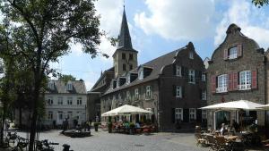 a large building with a church with a tower at Hübsches Cottage in ehemaliger Gärtnerei in Meerbusch +20 photos